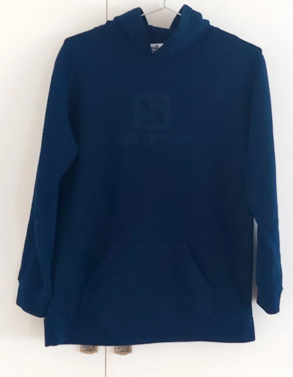 Buzo canguro azul marino de la marca Salomon, con capucha y bolsillo frontal. Ideal para actividades deportivas o uso casual. Talle 14.