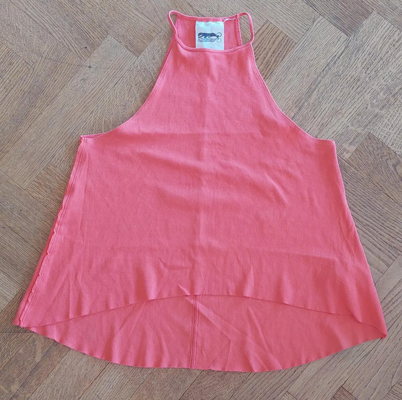 Musculosa de mujer, color coral, con cuello halter y espalda descubierta. Ideal para un look fresco y moderno. Marca Jazmin Chebar.