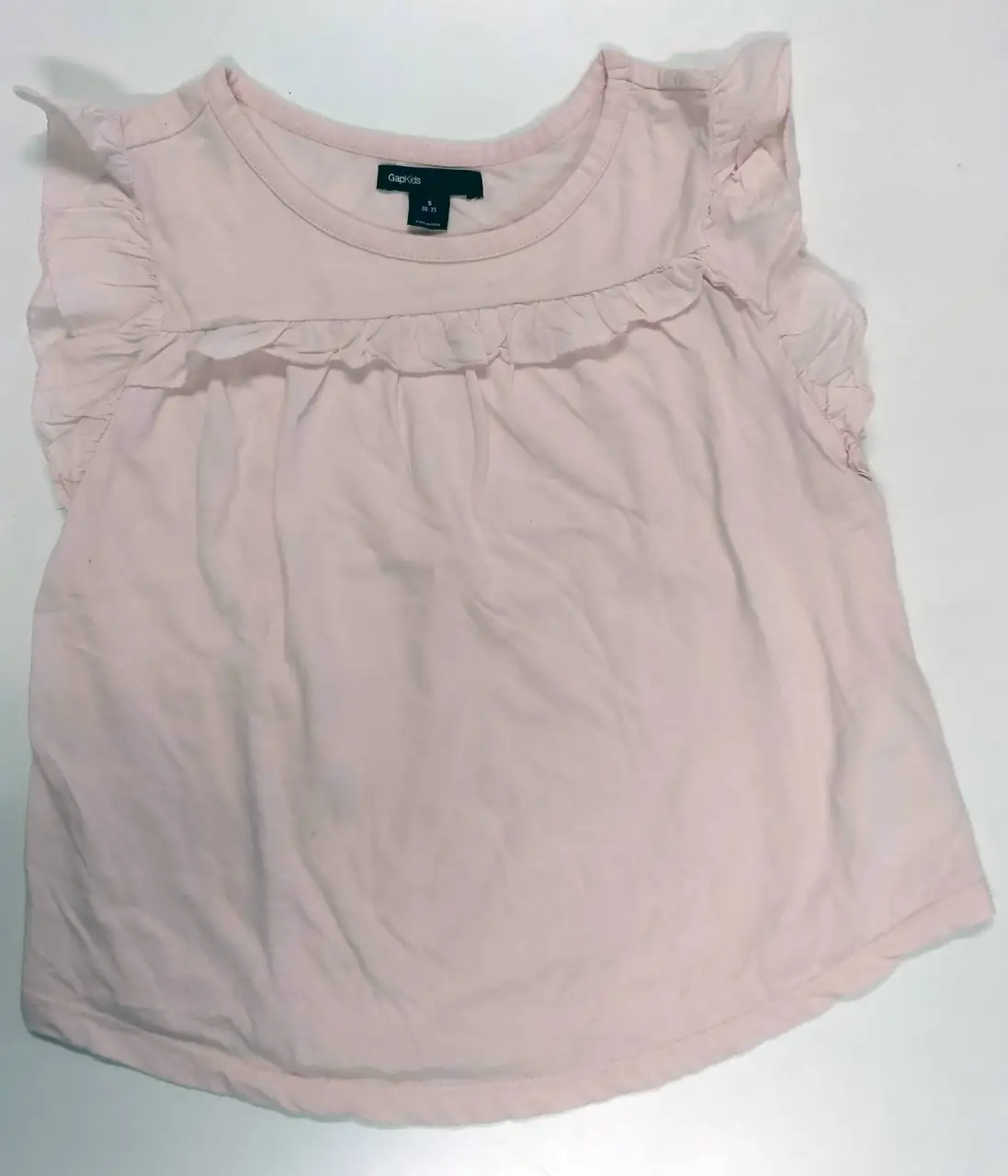 Blusa rosa para niña, con volados en los hombros y detalle en el frente. Ideal para un look casual y fresco.