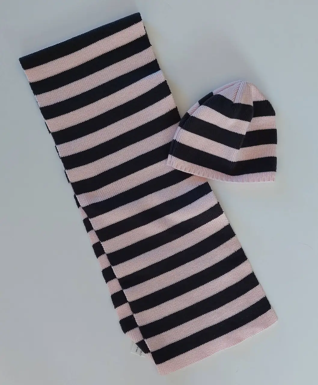 Conjunto de bufanda y gorro a rayas en color rosa y negro, ideal para el invierno. Fabricado en acrílico.