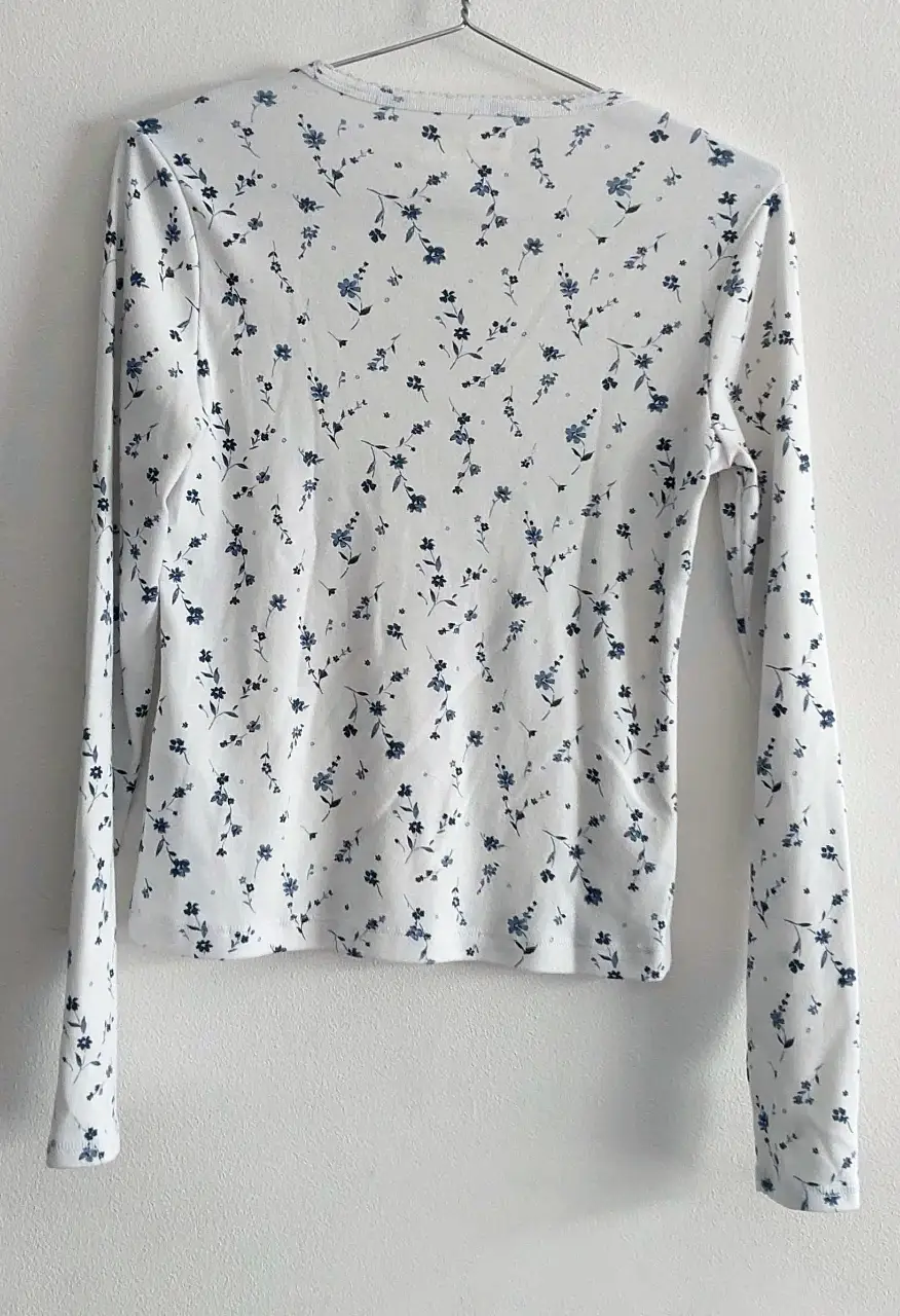 Remera manga larga para niña, con estampado floral en tonos azules sobre fondo blanco. De la marca Abercrombie Kids. Ideal para un look casual y cómodo.
