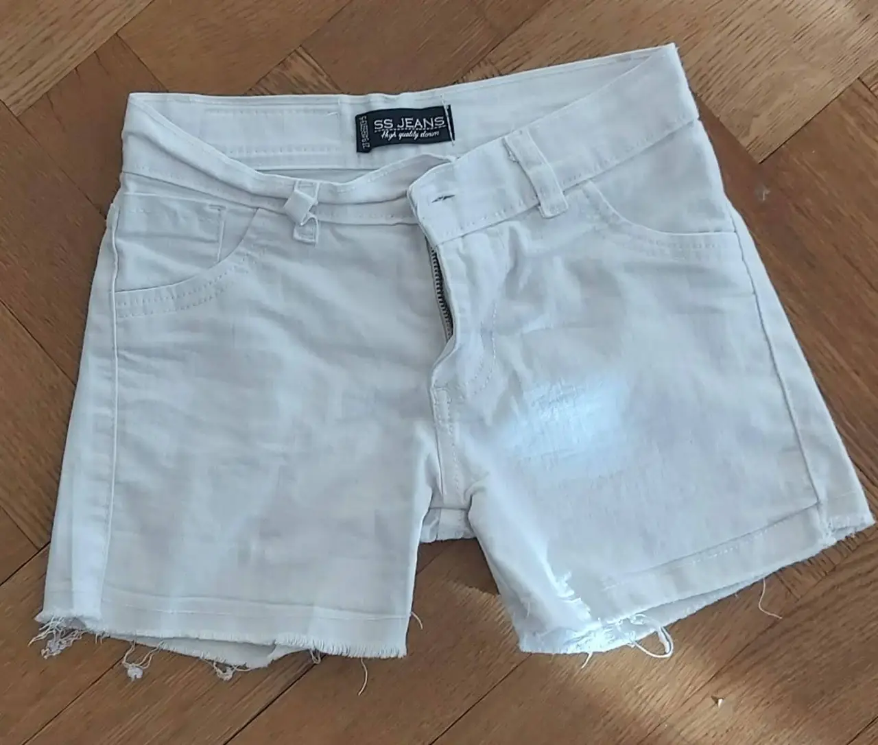 Short de jean blanco de niña, con bolsillos delanteros y traseros. Marca Sony Sol. Ideal para un look casual y fresco.