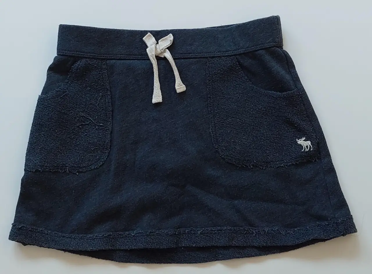 Short deportivo de niña, color negro, con bolsillos y cintura elastizada, con calza incluida. Ideal para actividades deportivas o uso casual.