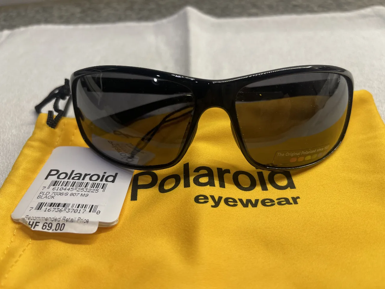 Anteojos de sol polarizados Polaroid, con marco negro y lentes oscuros. Incluye funda protectora.