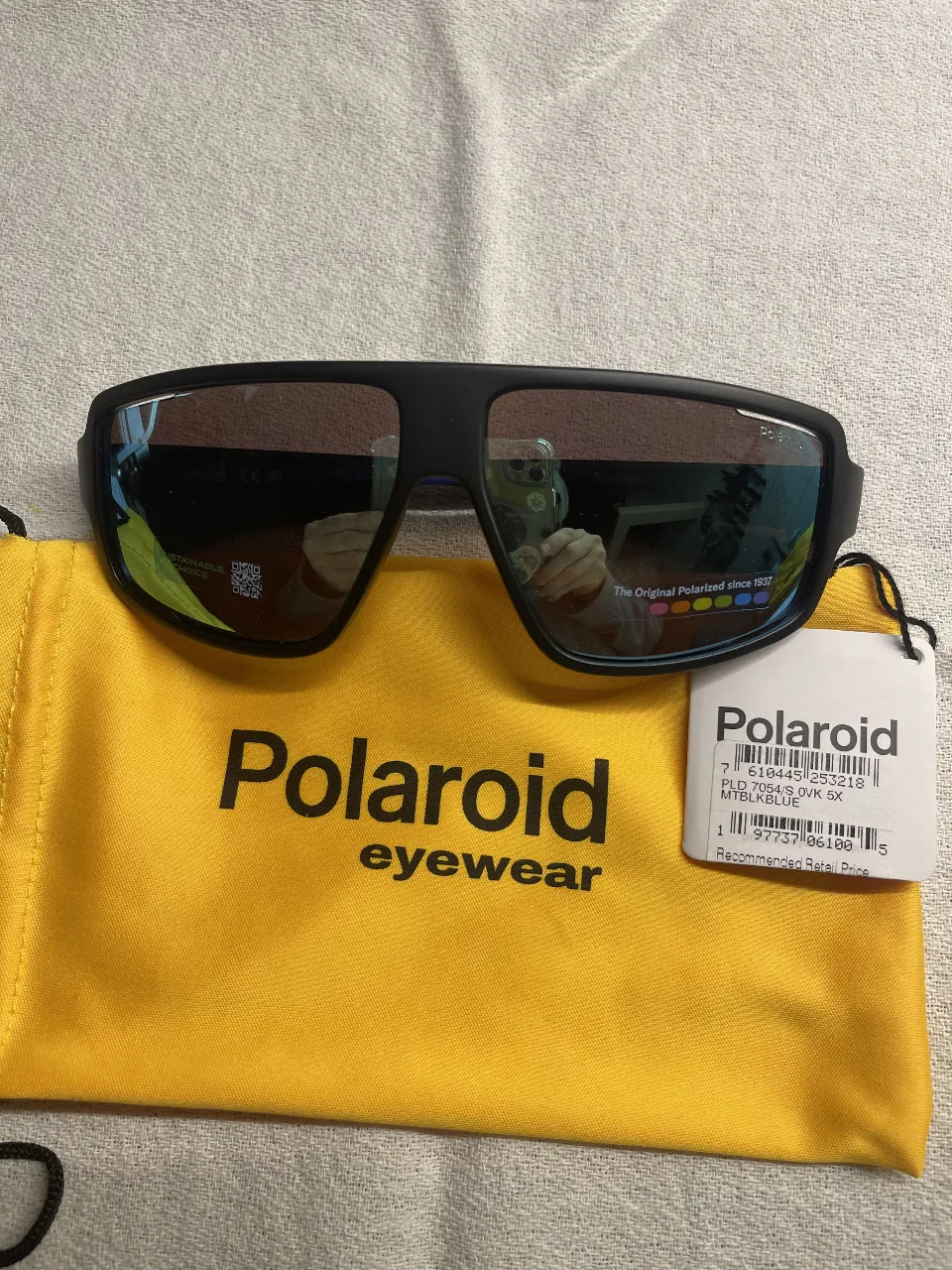 Anteojos de sol Polaroid, modelo PLD 7039/S 9X M1BLKBLUE. Diseño deportivo con marco negro y detalles en azul. Incluye funda.