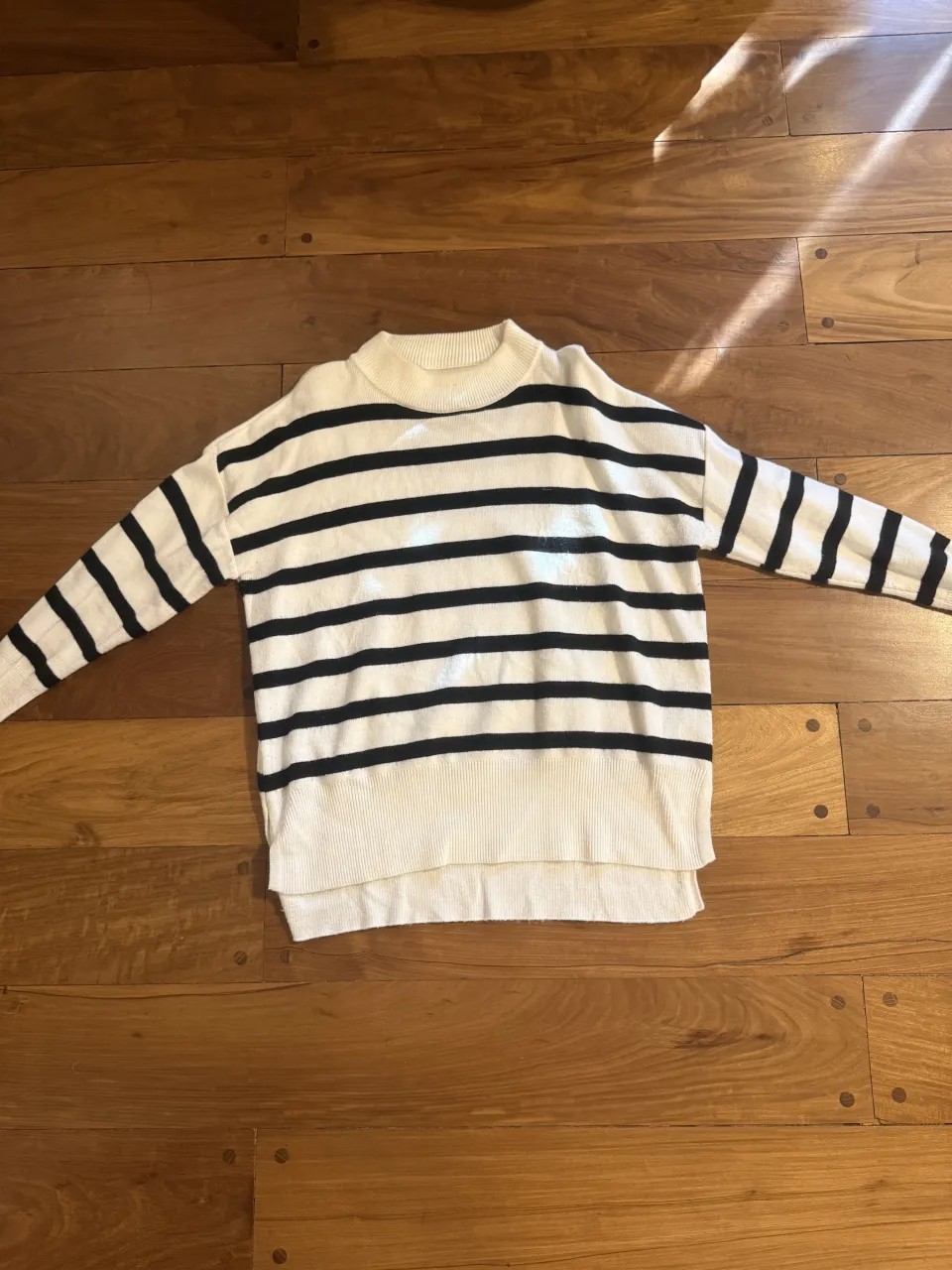 Sweater de rayas blancas y negras, con cuello redondo y mangas largas. Un clásico que no puede faltar en tu guardarropa, ideal para un look casual y canchero.