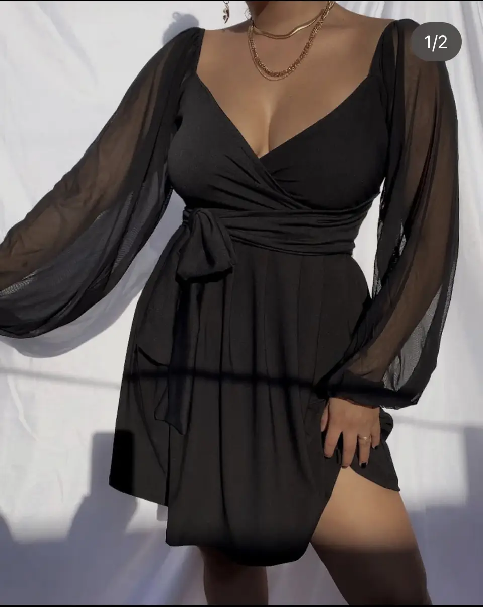 Vestido mini negro con mangas largas de gasa transparente y escote en V. Incluye un lazo en la cintura para ajustar y realzar la figura. Ideal para una fiesta o salida nocturna.
