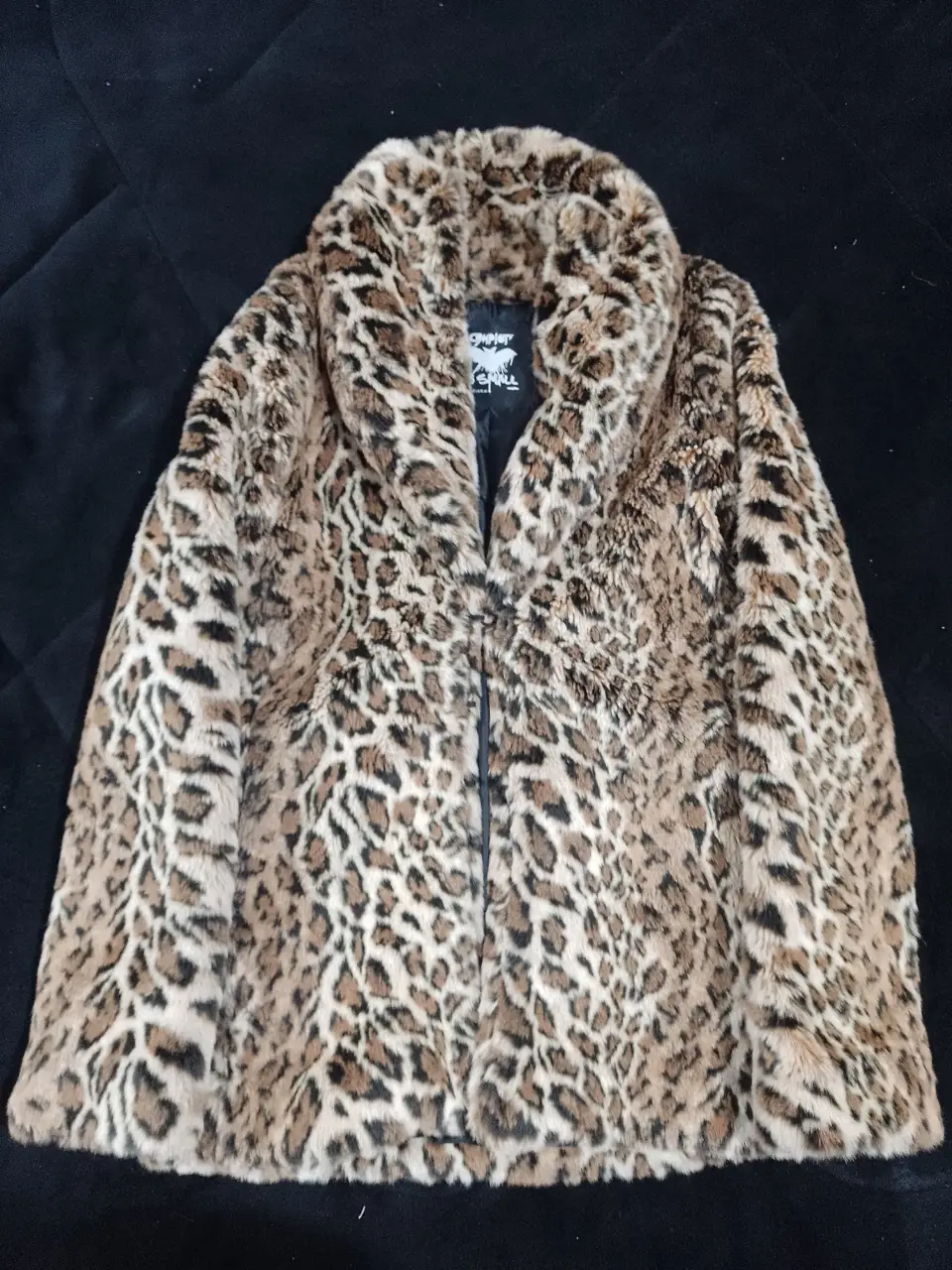 Tapado de piel sintética con estampado de leopardo. Cuello amplio y cierre con cremallera. Ideal para un look audaz y abrigado en invierno.