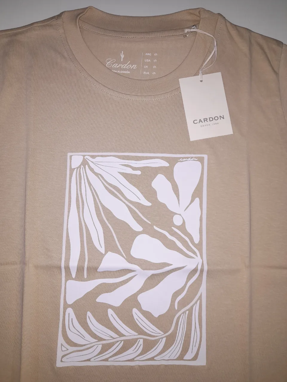 Remera de hombre color crudo con estampado floral en el frente. Marca Cardon, ideal para un look casual y cómodo.