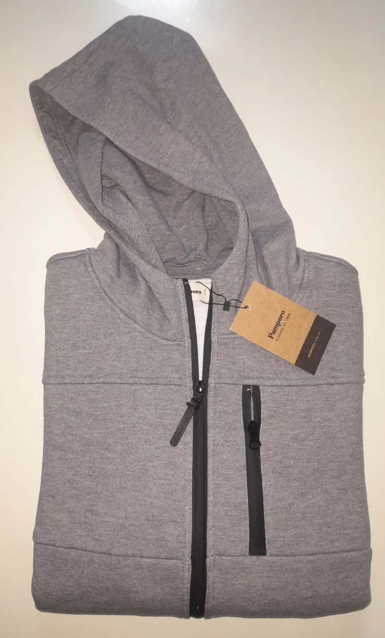 Buzo con cierre y capucha para hombre, de color gris. Posee un bolsillo en el pecho con cierre y dos bolsillos laterales. Ideal para un look casual y cómodo.