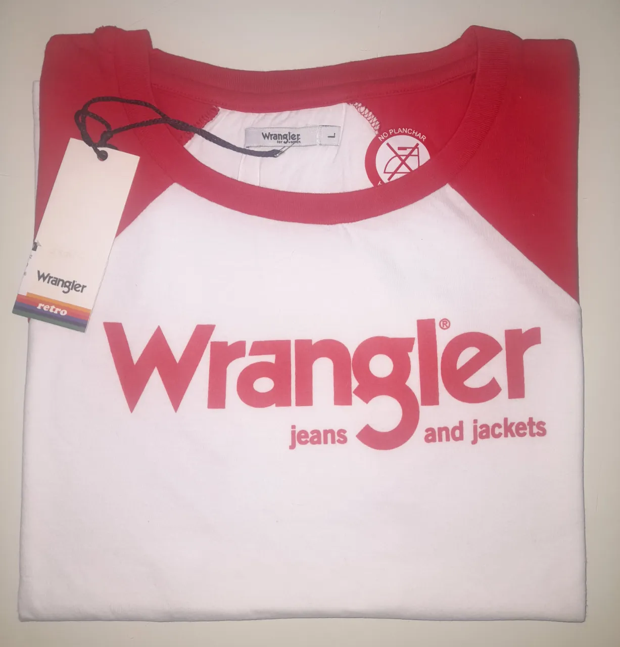 Remera Wrangler retro sin mangas, con diseño bicolor en rojo y blanco. Estampado grande del logo Wrangler en el frente. Ideal para un look casual y con onda.