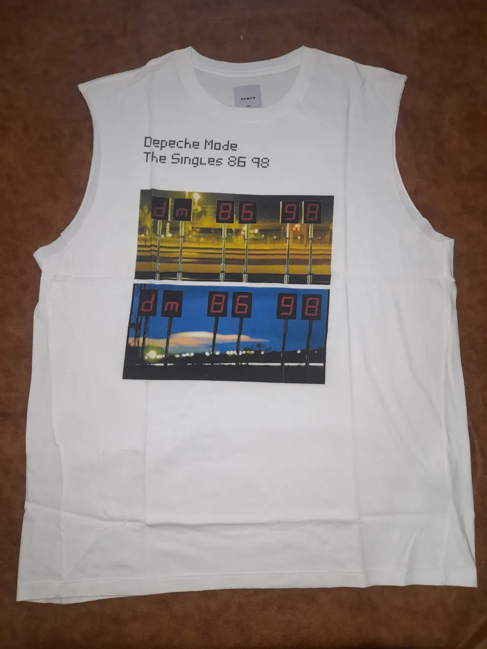 Musculosa blanca de algodón con estampado de Depeche Mode The Singles 86 98. Ideal para fans del grupo y amantes del estilo vintage. Marca Bowen.Talle L
