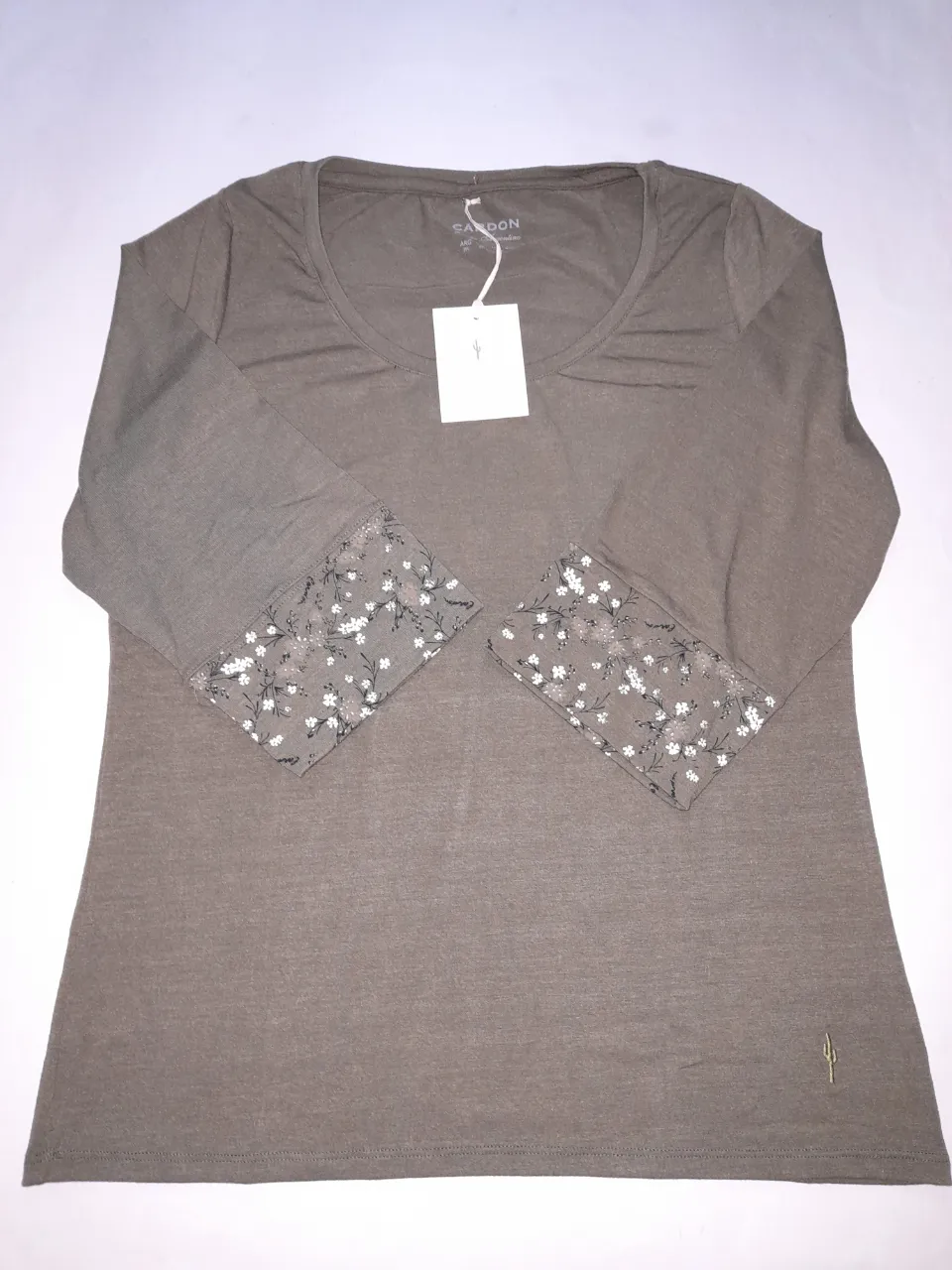 Remera manga 3/4 de color verde militar con detalles florales en los puños. Cuello redondo. Marca Cardon.