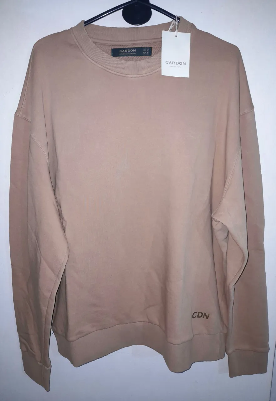 Buzo de cuello redondo color marrón claro de la marca Cardon. Diseño argentino. Impecable.Talle XL.