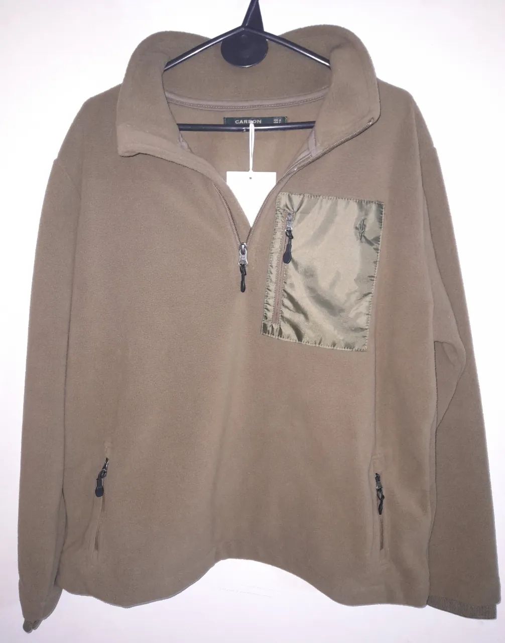 Buzo con cierre de polar, color verde musgo. Posee un bolsillo en el pecho con cierre y detalles en verde oscuro Bolsillos con cierre a los costados. Modelo Ezequiel. Ideal para el invierno.