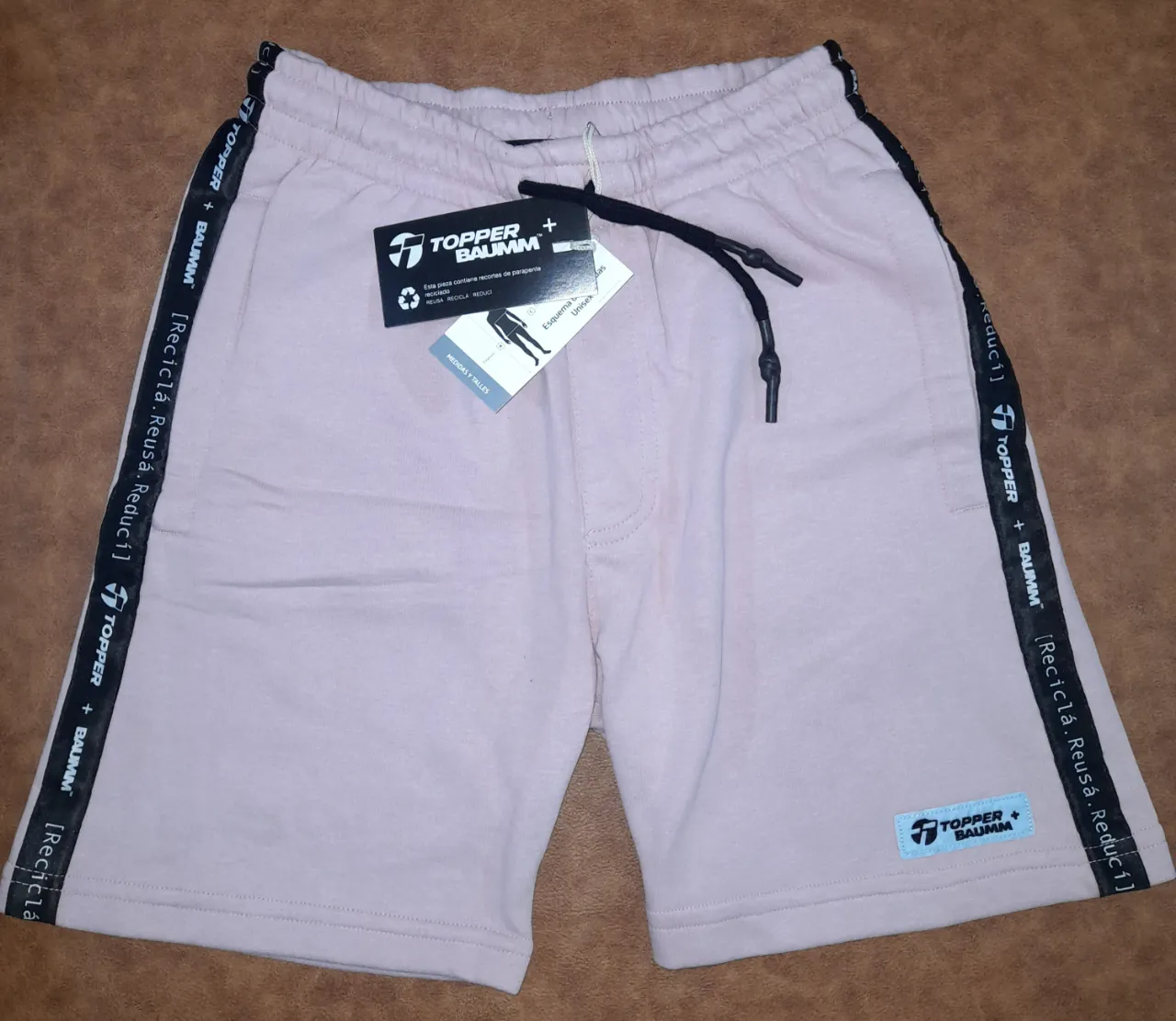 Short deportivo Topper Baumm en color rosa, talle XS. Con detalles en negro y logo de la marca. Ideal para actividades deportivas o uso casual.