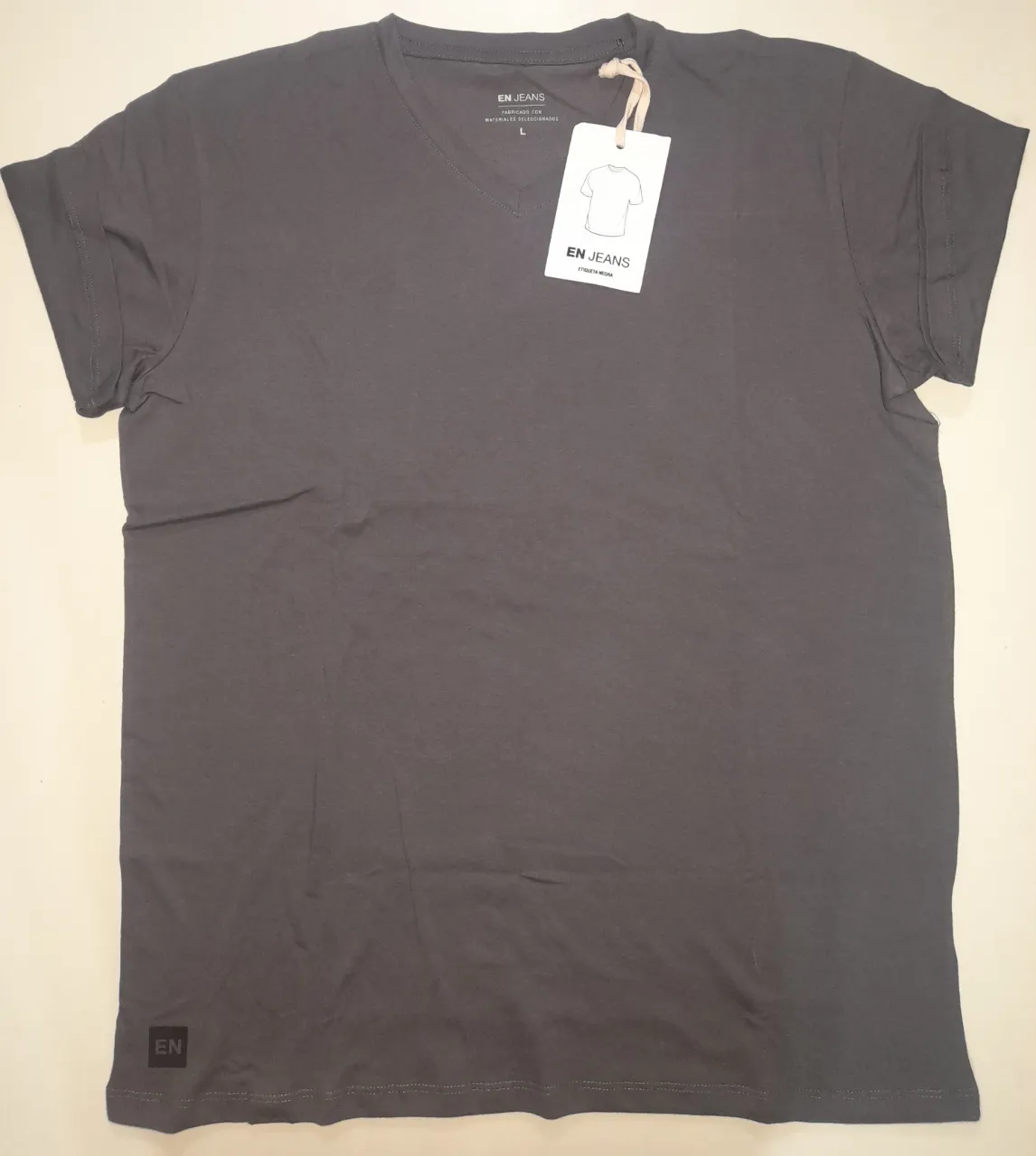 Remera de hombre con cuello en V, color gris oscuro. Marca EN JEANS. Talle L. Confeccionada en 100% algodón. Ideal para un look casual y cómodo. Única falla una línea en la parte izquierda. Foto 5