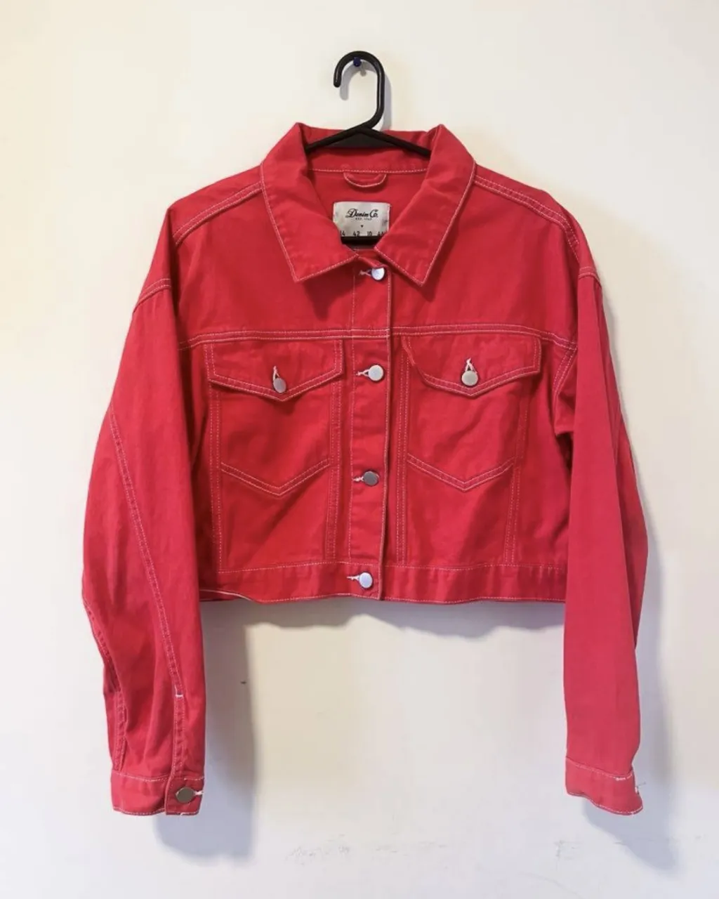 Campera de jean roja, estilo corta y con pespuntes blancos. Ideal para darle un toque canchero a cualquier outfit.