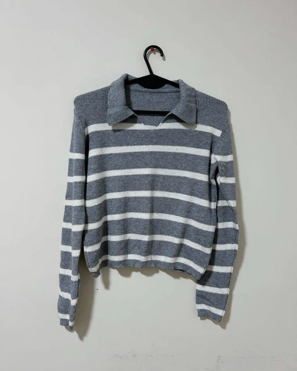 Sweater de tejido a rayas grises y blancas, con cuello polo y manga larga. Un básico canchero para cualquier ocasión.