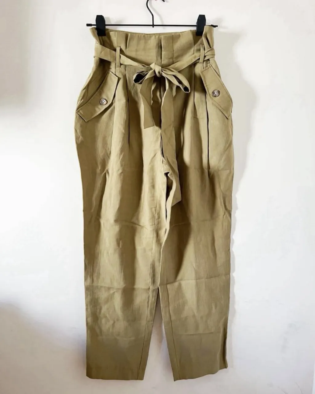 Pantalón de vestir color verde militar, tiro alto, con lazo para atar en la cintura. Tiene bolsillos cargo a los costados y un corte recto en la pierna. Ideal para un look canchero y cómodo. talle numerico es US 8