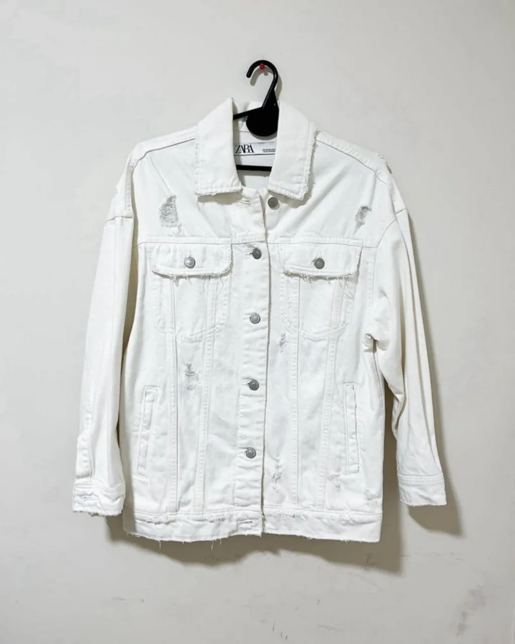 Campera de jean blanca, con roturas y detalles deshilachados. Un clásico renovado para darle un toque canchero a cualquier outfit.