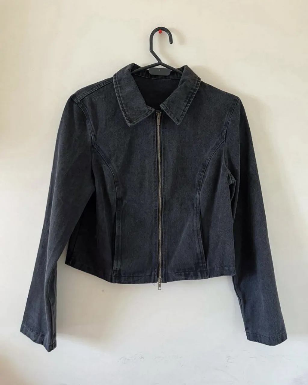 Campera de jean negra, corta y con cierre. Ideal para un look casual y moderno.