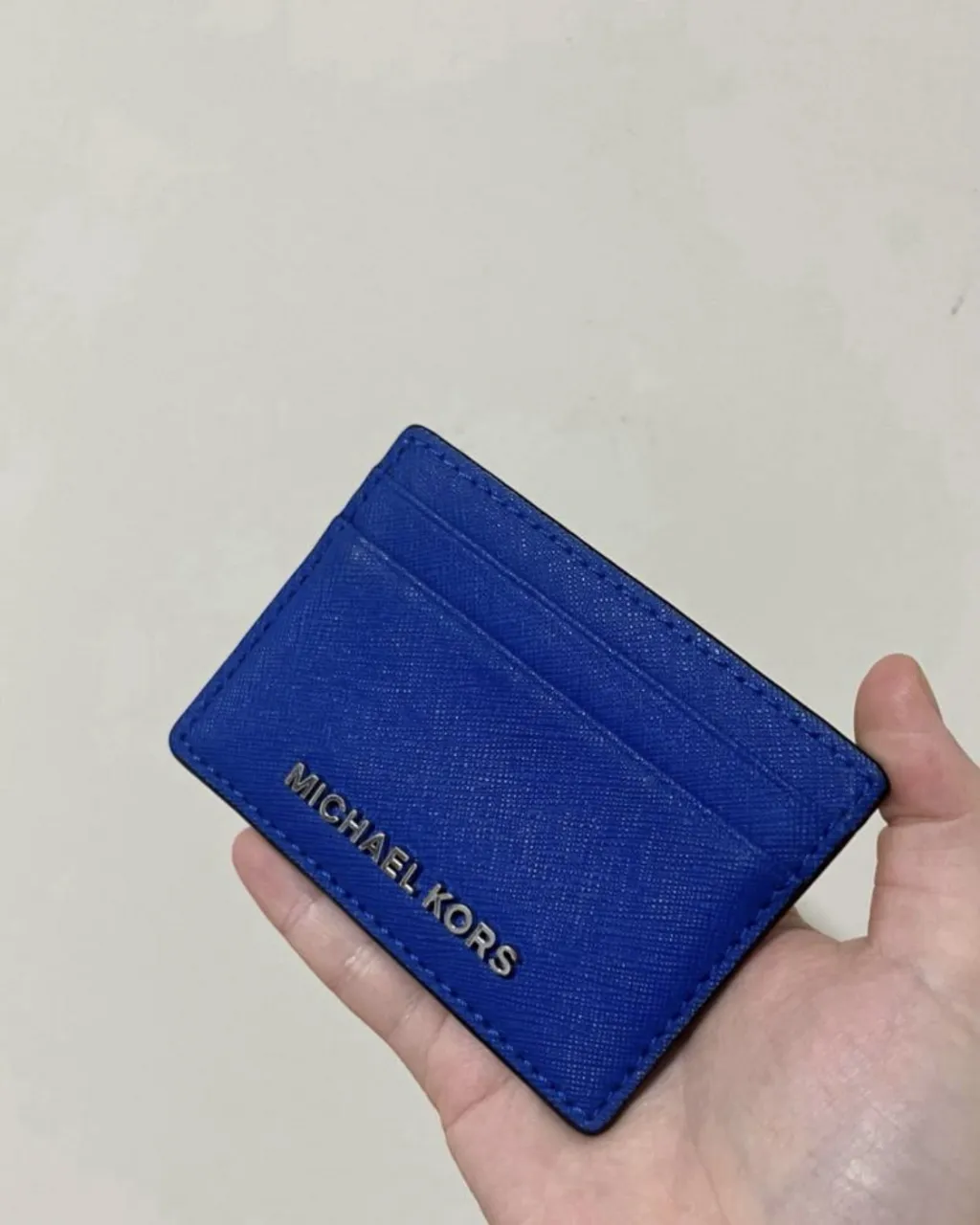 Portatarjetas Michael Kors azul eléctrico, ideal para llevar tus tarjetas esenciales de forma organizada y con estilo. Perfecto para el día a día o para complementar un look más arreglado.