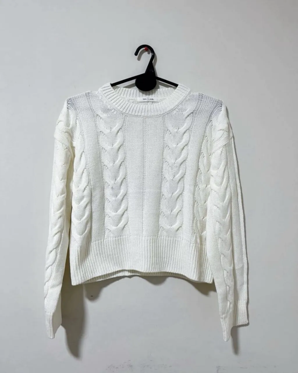 Sweater blanco de tejido grueso con trenzas. Cuello redondo y mangas largas. Un básico ideal para el frío, perfecto para combinar con jeans o polleras.