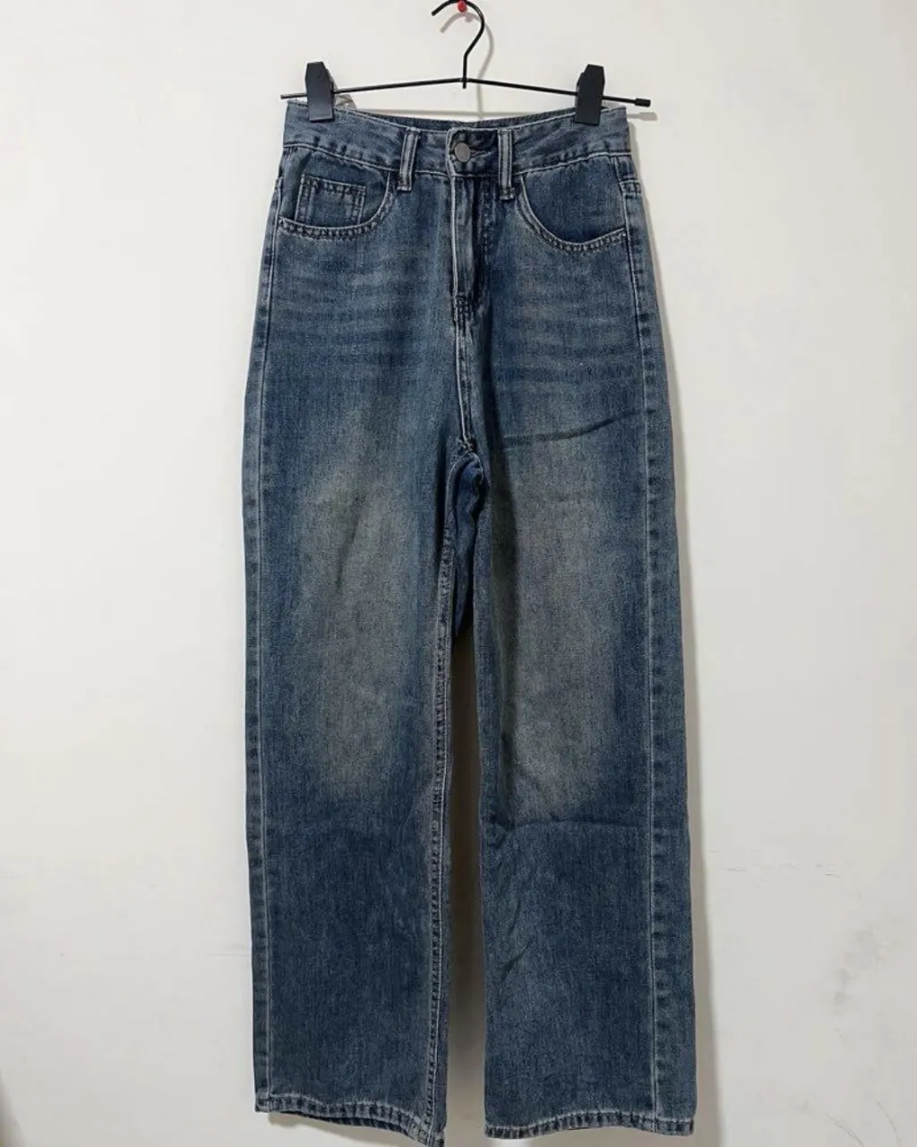 Jeans tiro alto, corte recto y pierna ancha. Lavado desgastado con detalles de desgaste. Perfectos para un look casual y moderno.