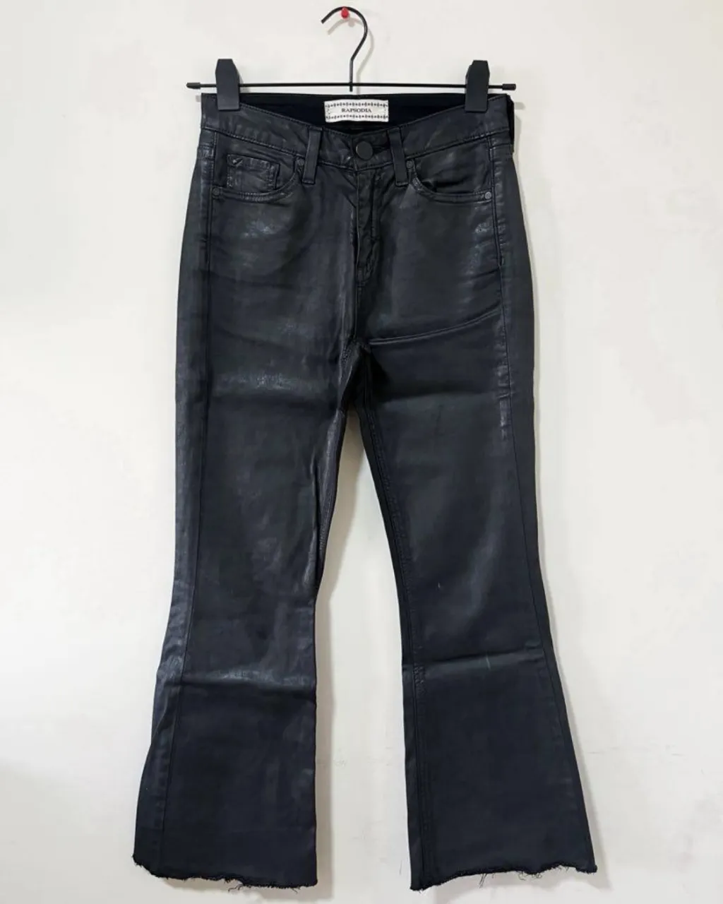 Pantalón de cuero negro, tiro alto, con corte acampanado. Un básico con un toque rockero para elevar cualquier look. cintura mide 33cm, cadera 44cm y largo 88cm 