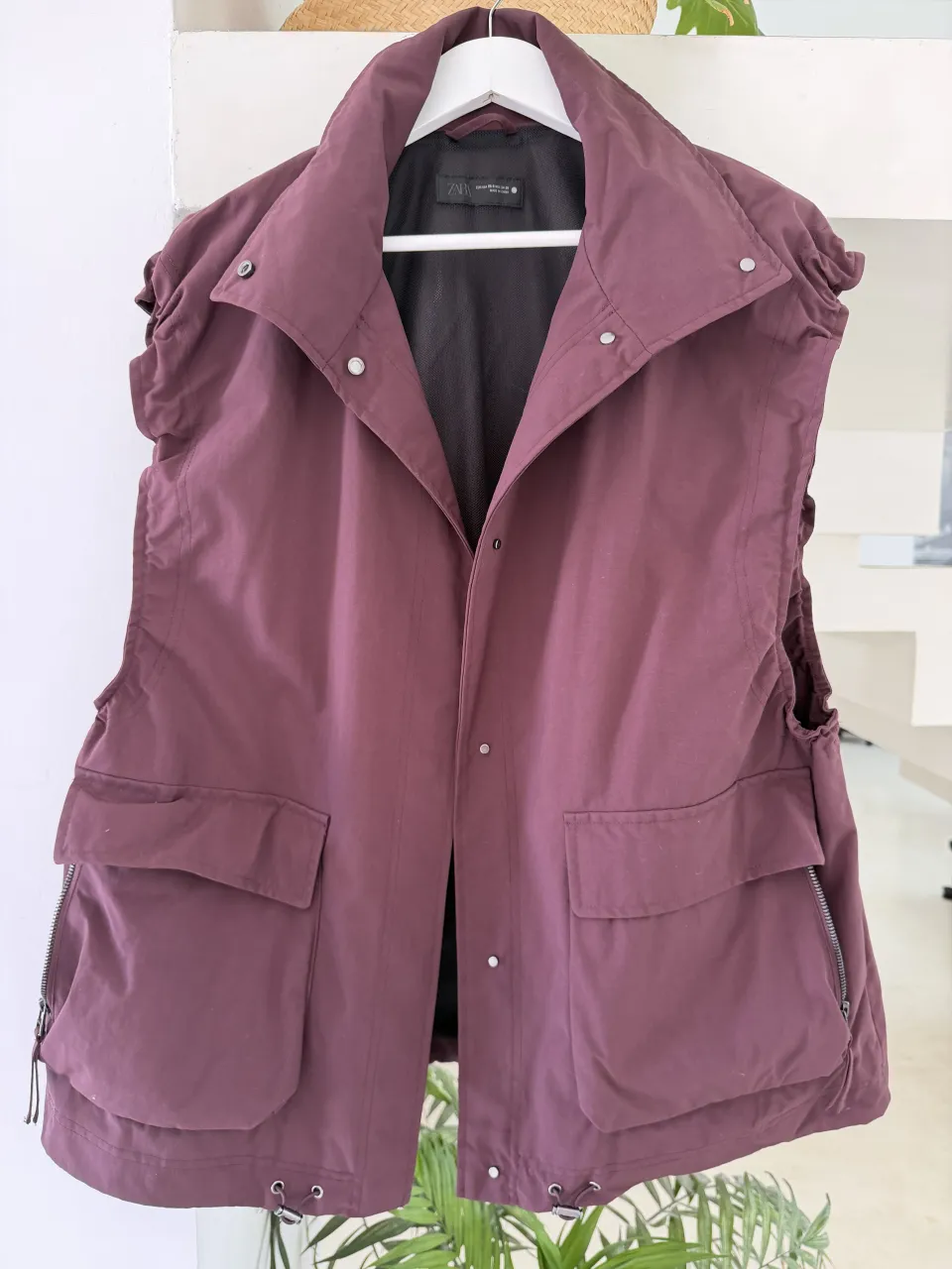 TALLE S OVERSIZE. Chaleco de color bordo con cuello mao, bolsillos frontales con solapa y cierre lateral. Tiene broches metálicos en el frente y en el cuello.