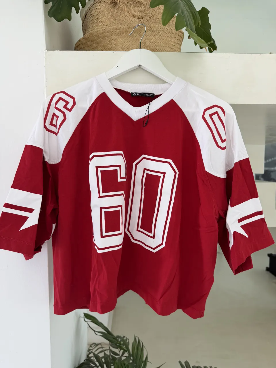 Remera roja con mangas blancas y detalles de rayas blancas en las mangas. Estampado grande con el número "60" en blanco en el frente. En la espalda, estampado "LAS VEGAS 1973 NEVADA" en blanco.