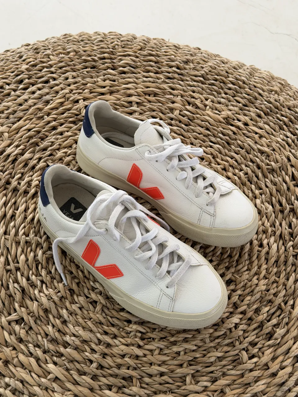 Zapatillas blancas de cuero con detalles en naranja y azul marino. Cordones blancos.