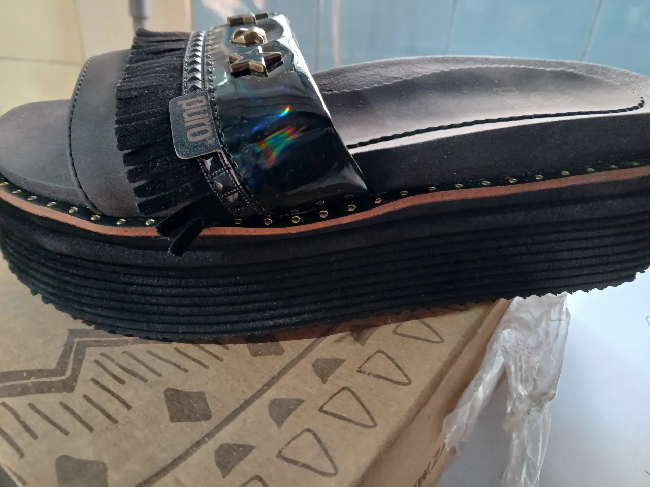 Sandalias de plataforma negras con detalles de tachas y flecos. Ideales para un look casual y moderno.