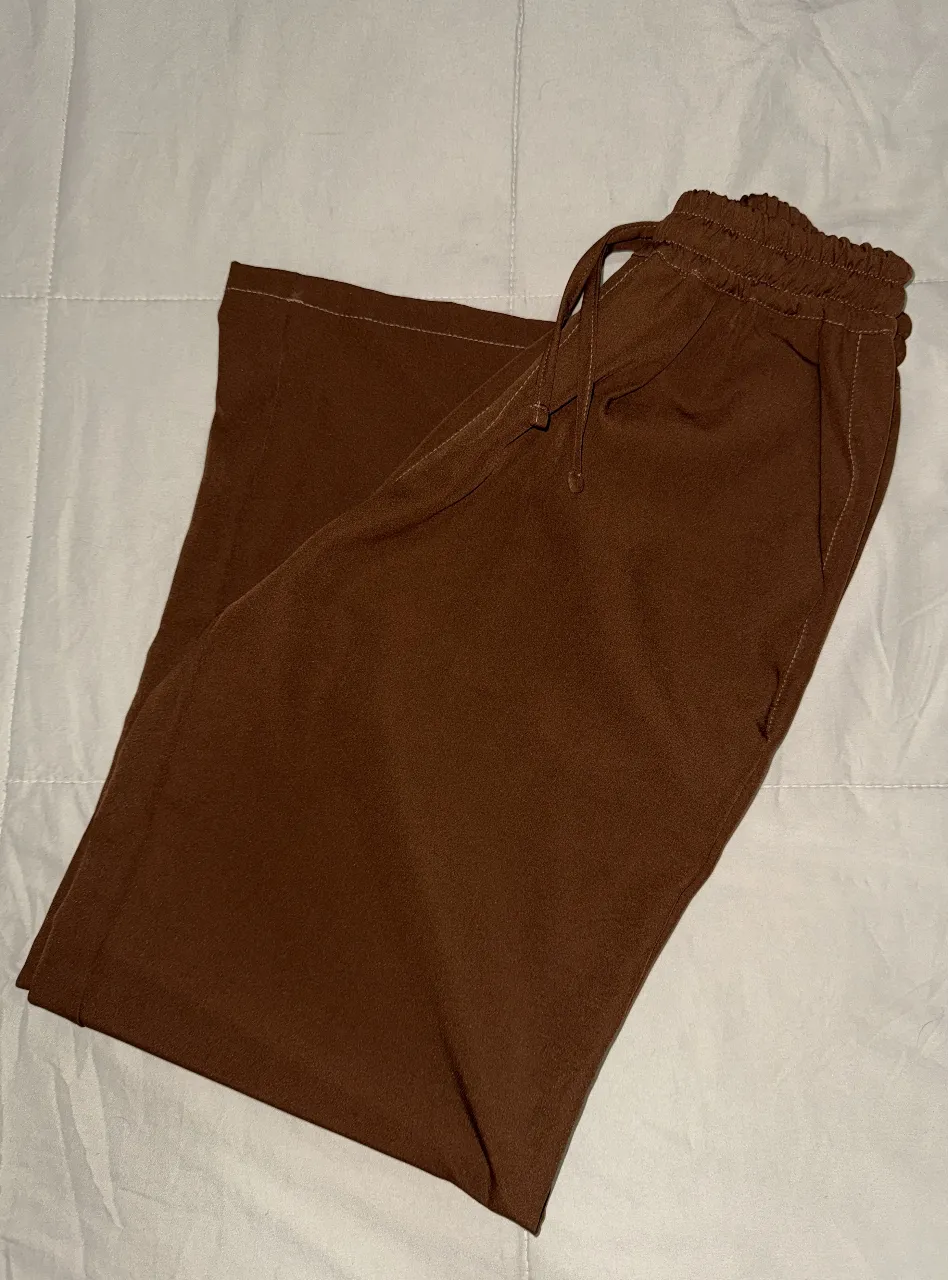 Pantalón suelto de color marrón, ideal para un look casual y cómodo. Confeccionado con tela suave y diseño versátil, perfecto para combinar con diferentes estilos.