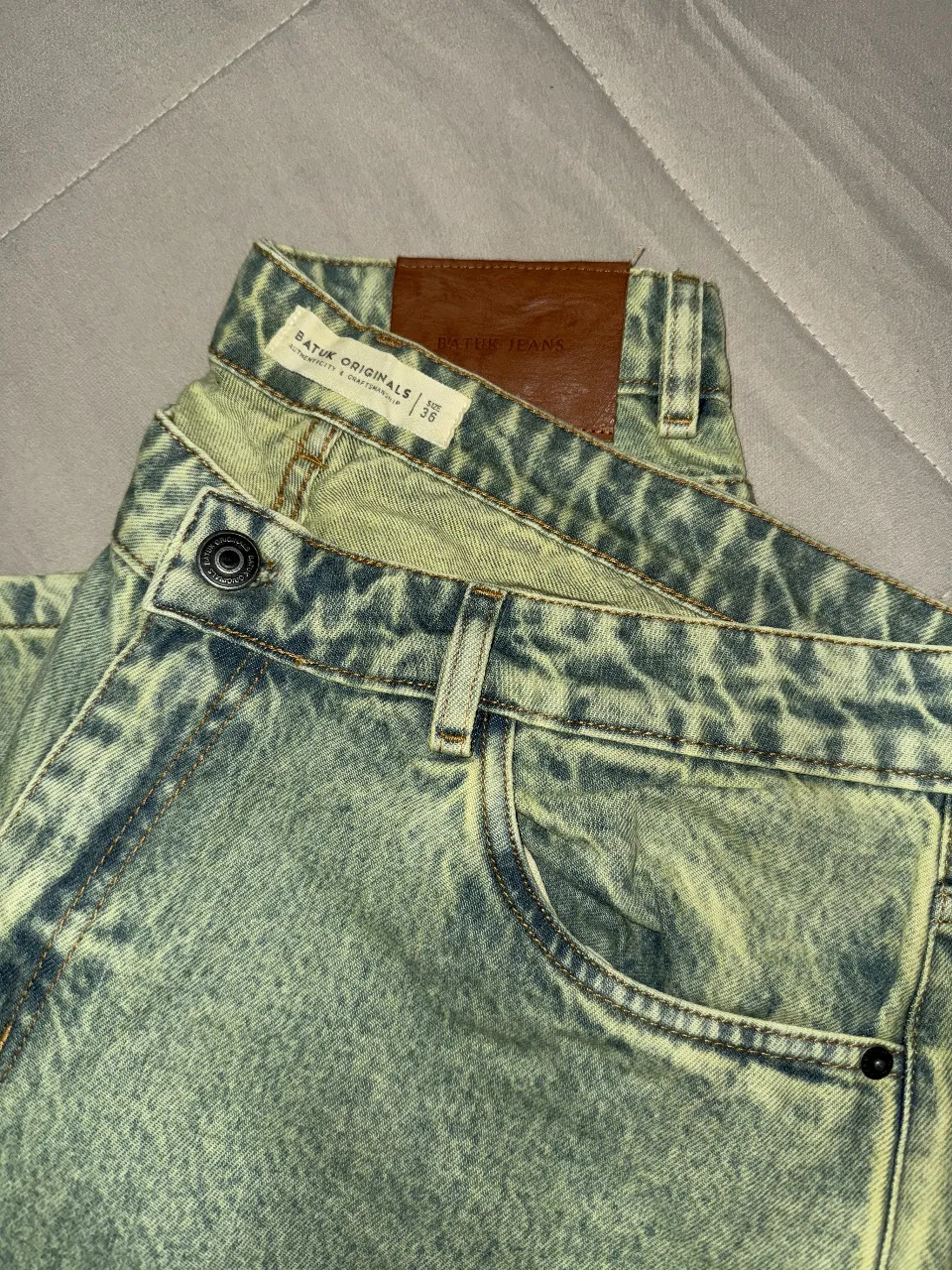 Jeans recto UNISEX con efecto gastado en tonos verde y azul. Tiro medio, ideales para un look casual y moderno. Marca: Batuk Originals.