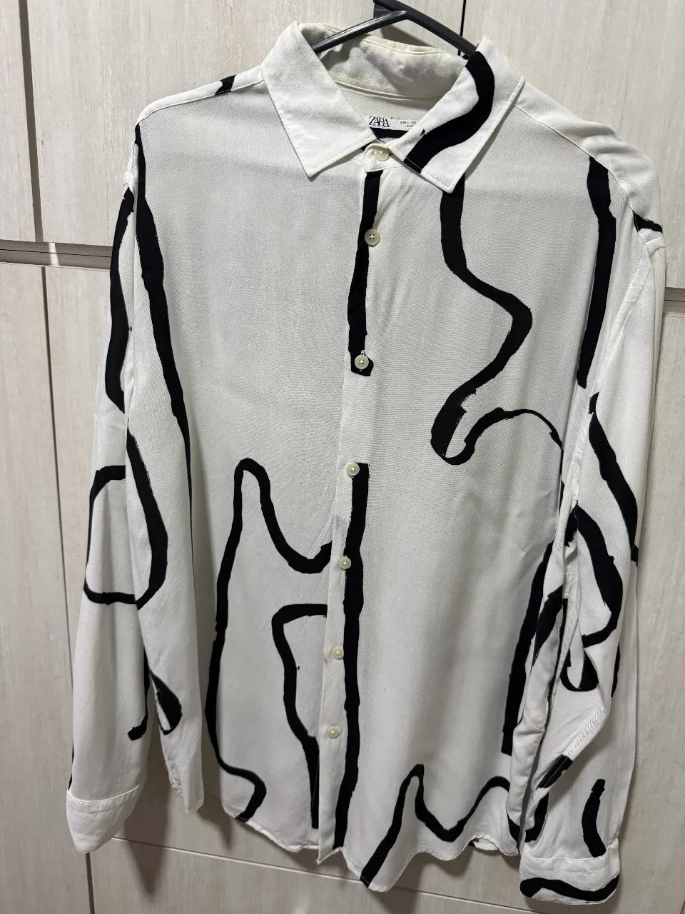 Camisa estampada de hombre, con diseño abstracto en blanco y negro. Corte regular fit, ideal para un look casual y moderno. Marca Zara, talle L.