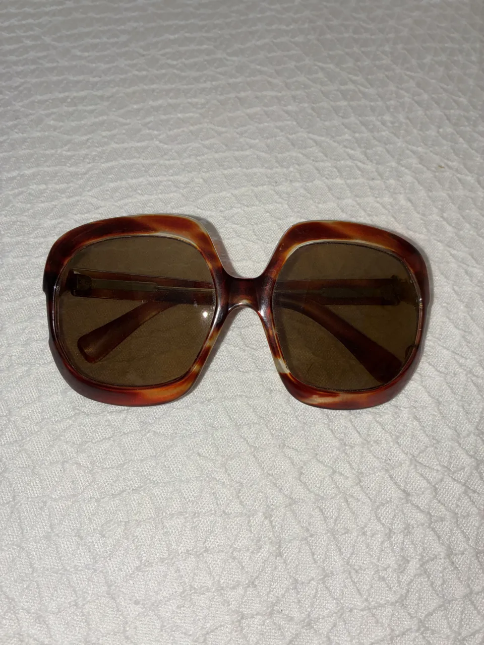 Anteojos de sol con armazón de acetato color carey y lentes marrones.