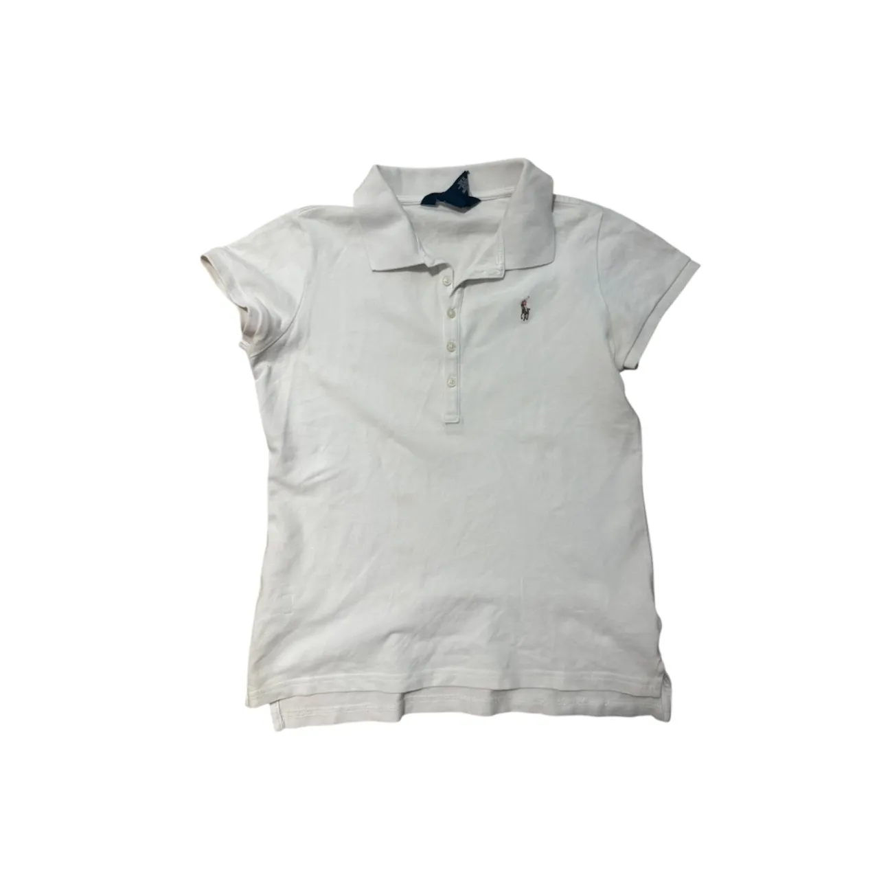 Remera blanca de manga corta con cuello polo y tres botones. Presenta un pequeño bordado de un caballo en el frente. talle 12/14 niños