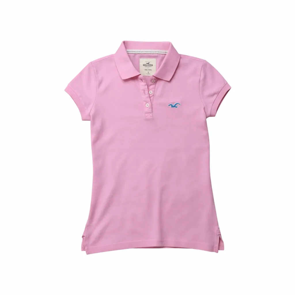 Remera polo rosa de manga corta con cuello y botones. Presenta un pequeño logo bordado en el frente.