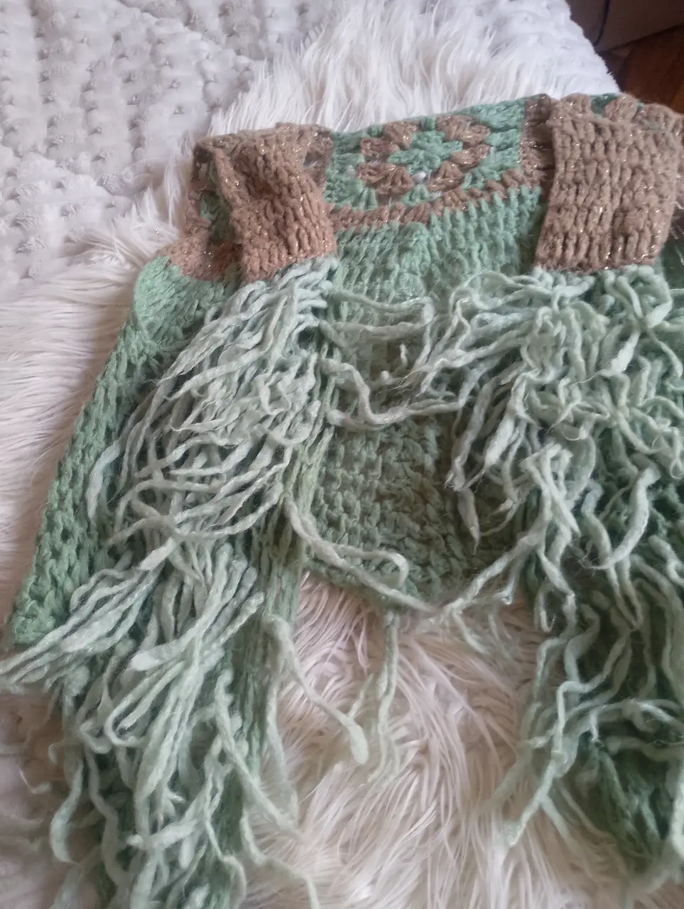 Chaleco tejido a mano en tonos verde y marrón, con flecos. Ideal para un look bohemio y artesanal.