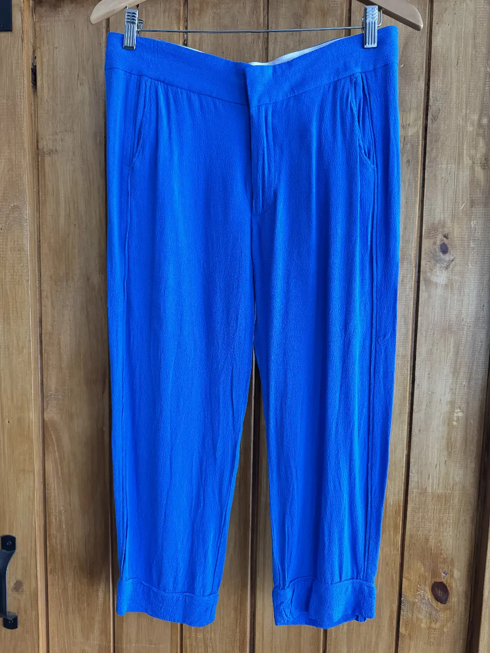 Pantalón sastrero azul, corte capri, con bolsillos delanteros y traseros. Ideal para un look elegante y fresco.