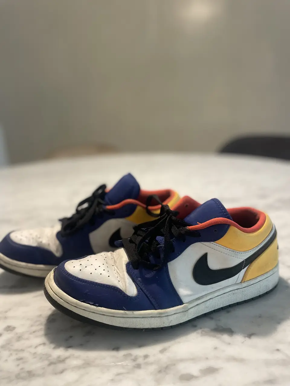 Zapatillas Air Jordan 1 Low, con detalles en azul, blanco, amarillo y negro. Ideales para un look casual y urbano. Talle 44.5 eur/ 10.5 us / mide 28.5 cm 