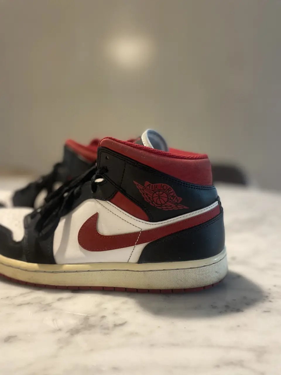 Zapatillas Air Jordan 1 Mid, con detalles en rojo y negro. Talle us 10.5/ eur 44.5/ mide 28,5 cm. Ideales para un look urbano y deportivo.
