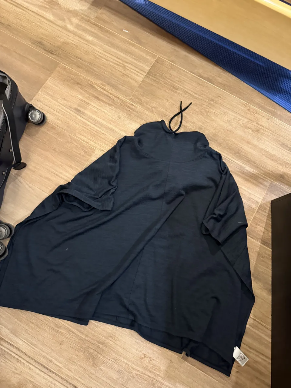 Buzo con capucha de color negro. Posee cordones para ajustar la capucha. Es un Poncho. En la etiqueta dice XS, pero es un M/L