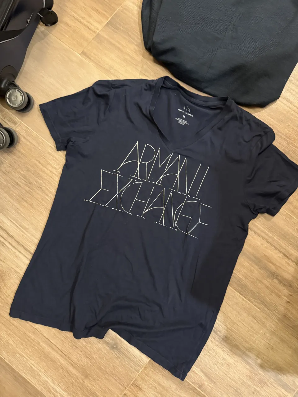 Remera azul marino de manga corta con cuello en V y estampa de la marca en el frente.