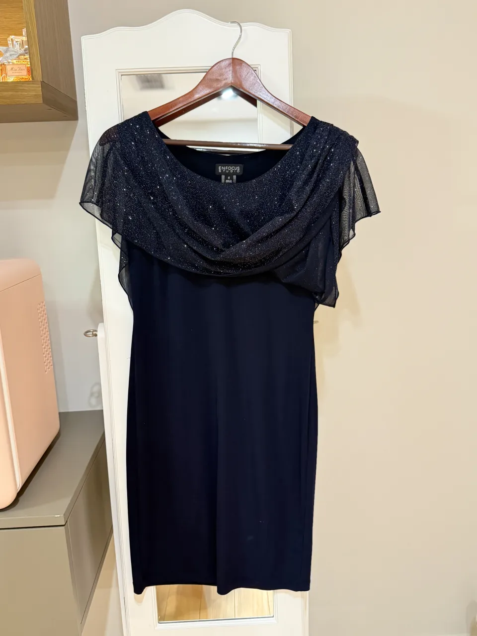 Vestido azul marino con detalles brillantes en la parte superior y mangas cortas tipo capa. La capa de brilla puede dejarse suelta 