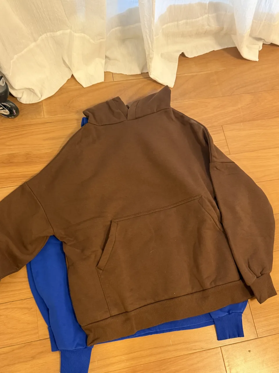 Buzo de friza color marrón con bolsillo canguro. Cuello redondo y puños elastizados.