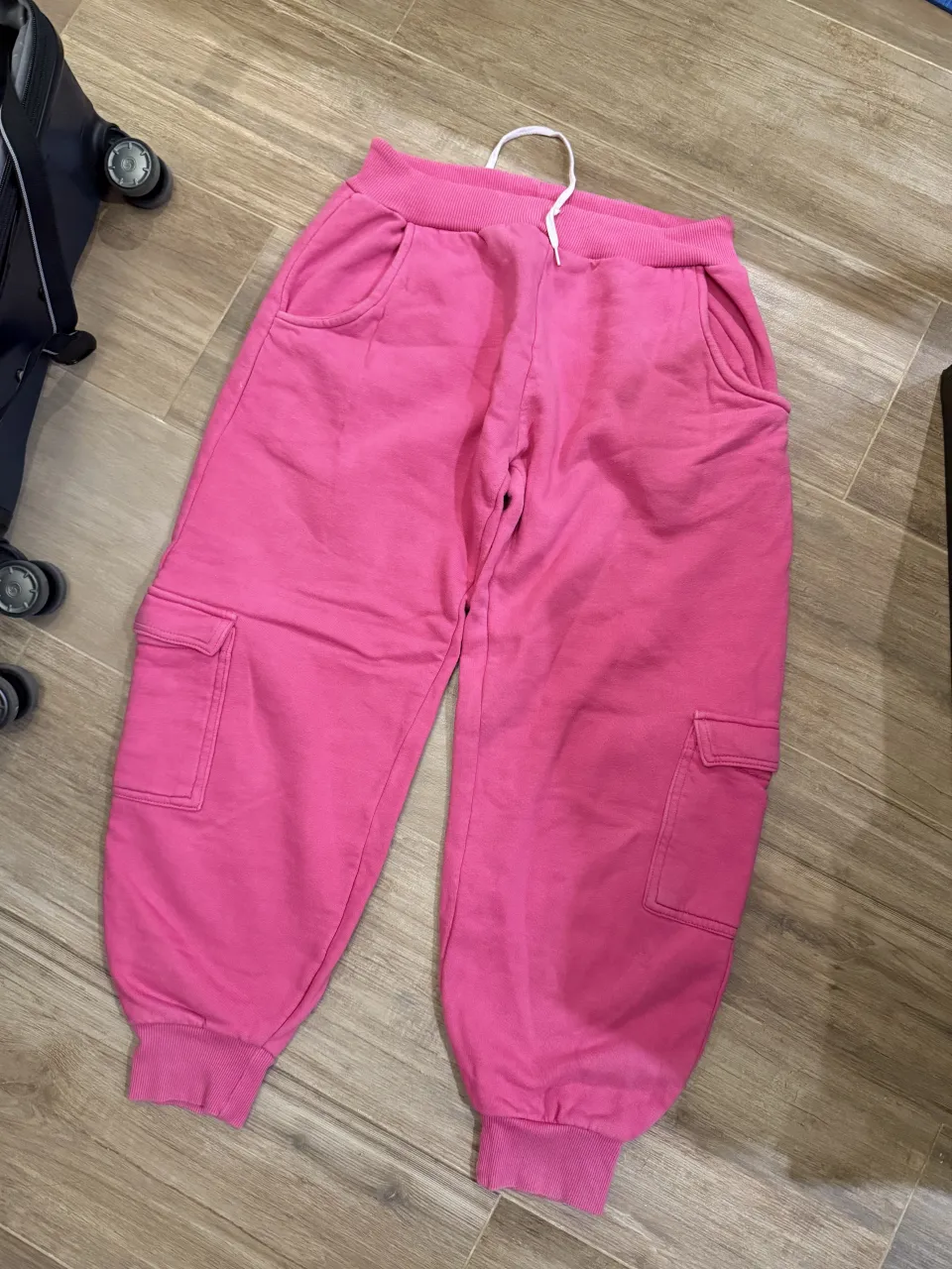 Pantalón de algodón color rosa con cintura elastizada y cordón blanco. Posee bolsillos laterales y bolsillos cargo con tapa en los laterales de las piernas. Puños elastizados en los tobillos.