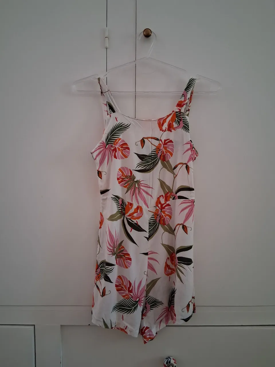 Mono corto blanco con estampado floral de flores y hojas en tonos rosas, naranjas y verdes. Talle S. Medidas: axila a axila 37 cm, largo 72 cm. 